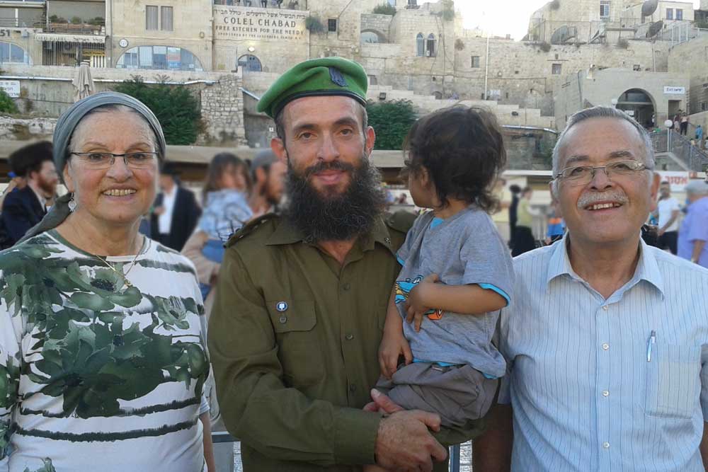 Rabbi Nechemia with his parents at the military course graduation